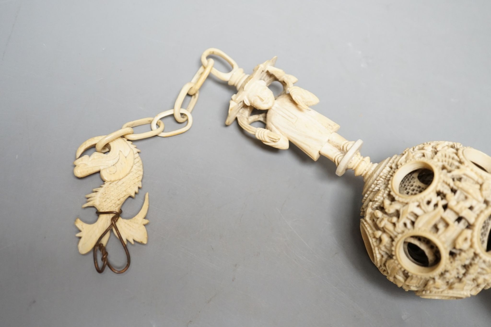 A 19th century Chinese export ivory puzzle ball., 31 cms long including chain.